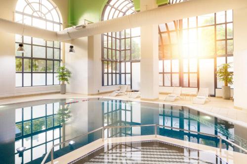 a large pool in a building with windows at Crowne Plaza Leeds by IHG in Leeds