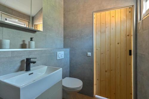 a bathroom with a sink and a toilet at Luxe Lodge voor 4 personen - Rolstoel-toegankelijk in Hoogersmilde