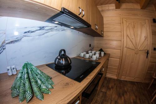 a kitchen with a stove with a tea kettle on it at Chatka Pod Laskiem - Domki w górach in Soblówka