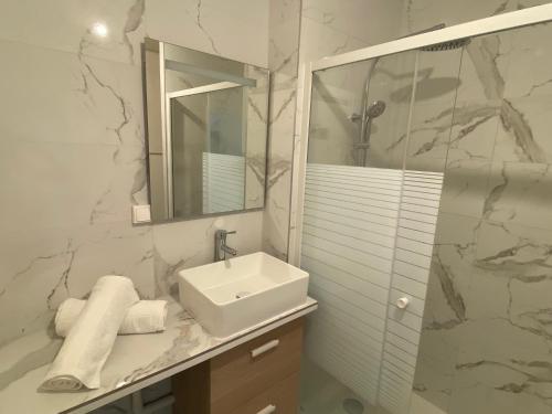 une salle de bain blanche avec un lavabo et un miroir dans l'établissement Appartement bassin de la villette, à Paris
