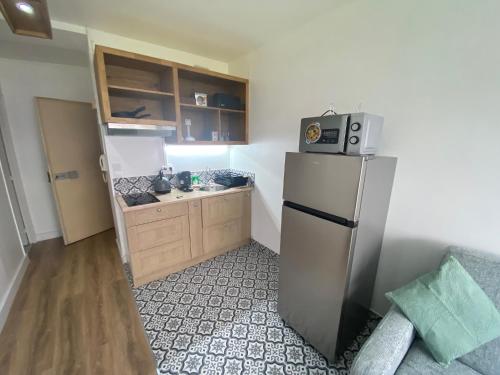 Il comprend une petite cuisine équipée d'un réfrigérateur et d'un comptoir. dans l'établissement Appartement bassin de la villette, à Paris