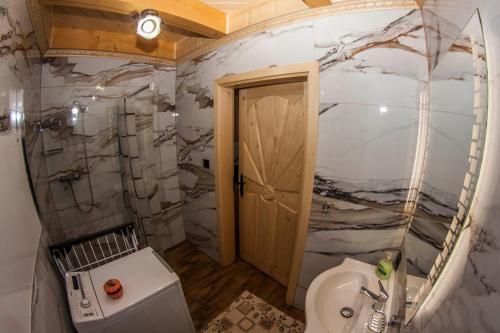 a bathroom with a white toilet and a sink at Chatka Pod Laskiem - Domki w górach in Soblówka
