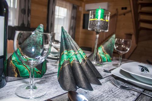 a table with wine glasses and napkins on it at Chatka Pod Laskiem - Domki w górach in Soblówka