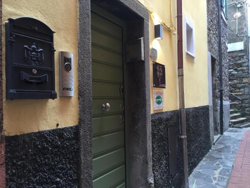 a green door on a building next to a street at La Linea D'Acqua in Manarola