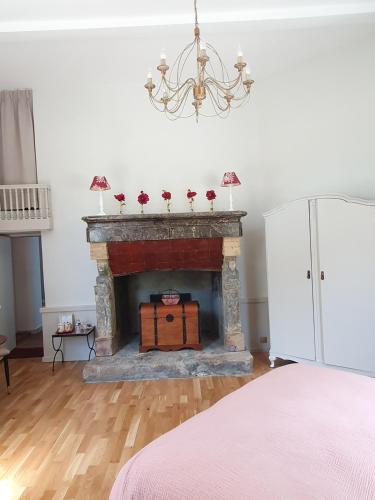 a living room with a fireplace with a chandelier at Château du Bois de La Noe in Bouaye