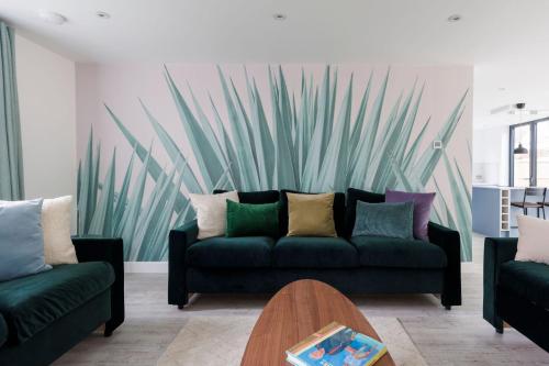 a living room with a couch and a wall with a painting at Coastal Retreat for 10 with Hot Tub in West Wittering