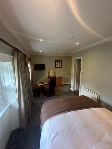 a bedroom with a bed and a desk and a television at Long Quay House in Kinsale