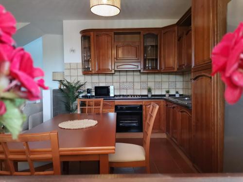 a kitchen with wooden cabinets and a table with chairs at Casa Sofia in Putzu Idu
