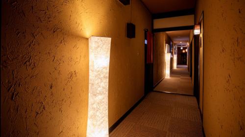 a hallway with a light on the side of a building at Omoideno Jinde in Izu