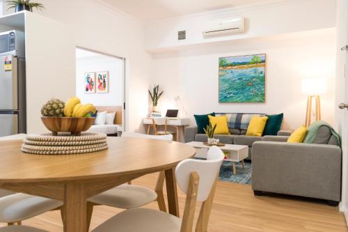 a living room with a table and a couch at Charming One-Bedroom Apartment in Northbridge in Perth
