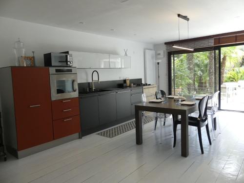 une cuisine avec une table et une salle à manger dans l'établissement Les palmes de Jade, à Saint-Brévin-les-Pins