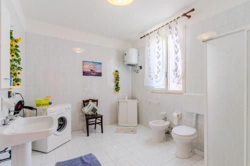 a white bathroom with a sink and a toilet at Casa Venere Luxury Apartment in Giuggianello