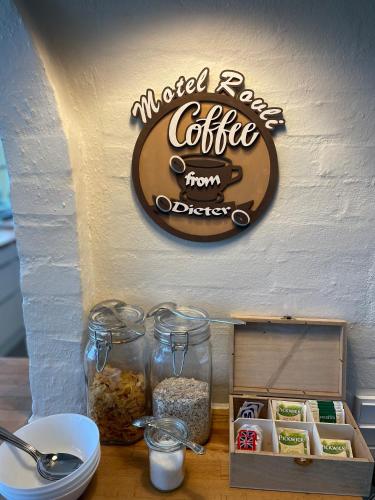 a sign for a coffee shop with containers of food at Motel Rovli in Skærbæk