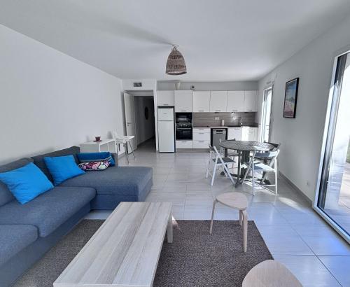 un salon avec un canapé bleu et une table dans l'établissement Superbe T3 avec jardin, résidence avec piscine et accés plages, à Saint-Cyr-sur-Mer