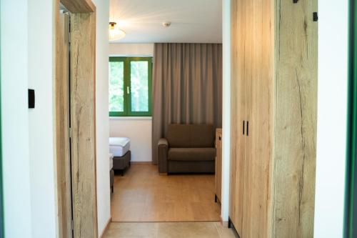 a hallway with a room with a bed and a chair at PÚŠŤ rekreačné stredisko in Prievidza