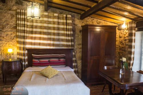 a bedroom with a bed and a desk and a table at Dar Zaghouan in Zaghouan
