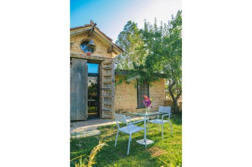 a stone cottage with a table and chairs in the yard at Dar Zaghouan in Zaghouan