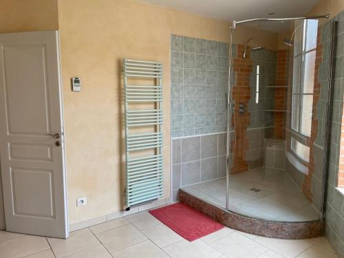 a shower with a glass door in a bathroom at maison de ville dans le perche in Senonches