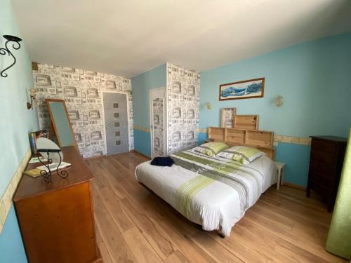 a bedroom with a large bed and blue walls at maison de ville dans le perche in Senonches