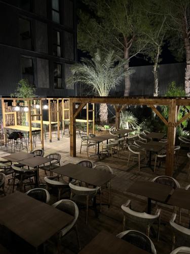 a patio with tables and chairs at night at Hôtel Le Relais des Brasseurs - Aubagne in Aubagne