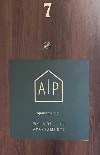 a sign on a door with the name of aap at Apartamenty Wolności 18 in Częstochowa