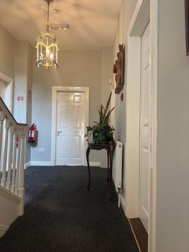 a hallway with a table and a chandelier at Long Quay House in Kinsale
