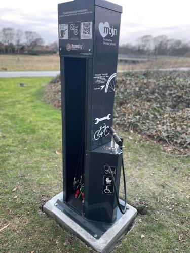 a gas pump sitting in the grass in a field at Motel Rovli in Skærbæk