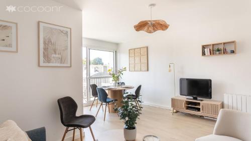 - un salon avec une table, des chaises et une télévision dans l'établissement Le Vauban - A 15min à pied de la plage, à Dinard