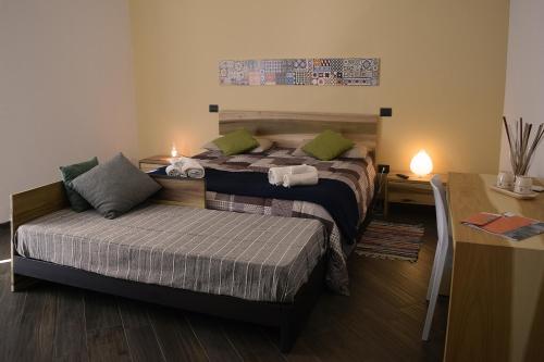 sypialnia z 2 łóżkami, stołem i biurkiem w obiekcie Culummi Bed & Breakfast w mieście Cavallino