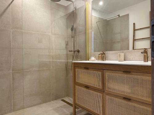 a bathroom with a shower and a sink and a mirror at Le Clos des Sept Palmiers in Cavalaire-sur-Mer