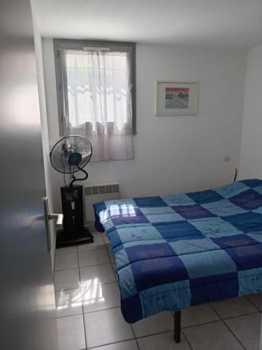 - une chambre avec un lit, un ventilateur et une fenêtre dans l'établissement Maison avec terrasse et piscine dans résidence à 6min de la plage, à Sainte-Marie-la-Mer