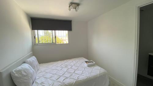 une chambre blanche avec un lit avec une fenêtre dans l'établissement NEMO Sanary, à Sanary-sur-Mer