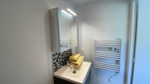une salle de bain avec un lavabo et un miroir dans l'établissement NEMO Sanary, à Sanary-sur-Mer