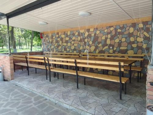 a row of benches in a room with a stone wall at Rancho Stepanavan in Maksim Gorʼkiy
