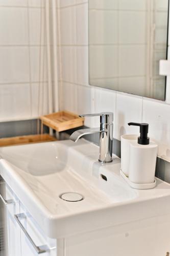une salle de bain avec un lavabo blanc et un miroir dans l'établissement Appartement paisible et central Rivoli - II, à Paris