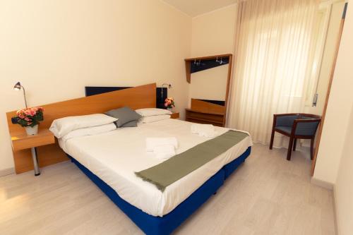 a bedroom with a large bed and a chair at Hotel San Pancrazio in Trescore Balneario