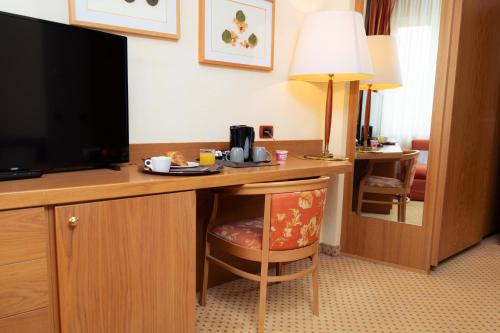 a hotel room with a desk with a flat screen tv at Hotel San Pancrazio in Trescore Balneario