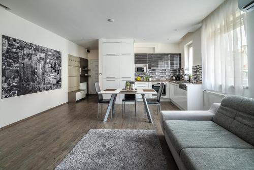 a kitchen and living room with a table and a couch at Geri Imádnivaló lakás Zalaegerszeg belvárosában in Zalaegerszeg