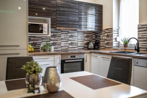 a kitchen with white cabinets and a counter top at Geri Imádnivaló lakás Zalaegerszeg belvárosában in Zalaegerszeg