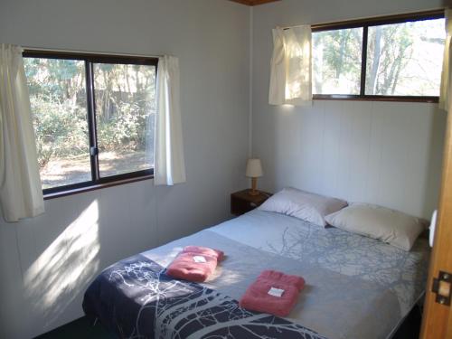 a bedroom with a bed with two pink towels on it at Launceston Holiday Park Legana in Legana