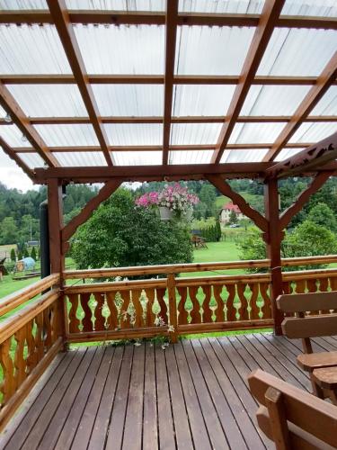 a wooden deck with a pergola and a bench at Jelonek Zawoja in Zawoja