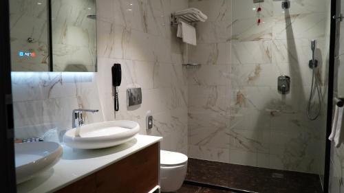 a bathroom with a toilet and a sink and a shower at Aniroc Signature Hotel in Arad