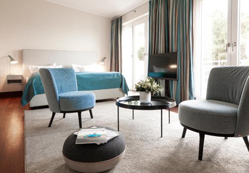 a hotel room with a bed and two chairs and a table at Hotel Fährhaus in Munkmarsch