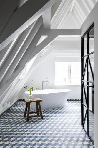 a bathroom with a white tub and a table at Kimpton De Witt Amsterdam by IHG in Amsterdam