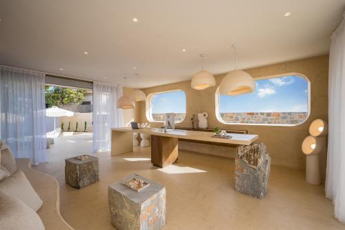 a living room with a desk and two large windows at Natali Apartments by Estia in Malia