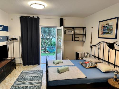 a bedroom with a bed and a door to a yard at Apartments Eti in Bol