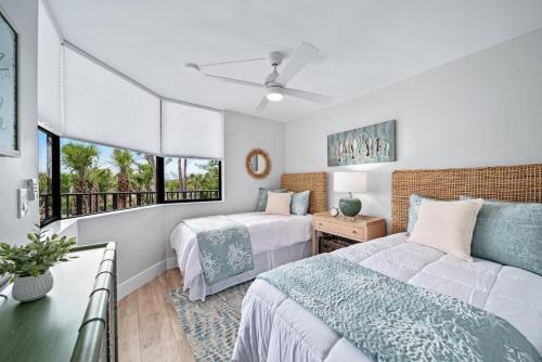 Un dormitorio con dos camas y una ventana. en Pine Cove #102, en Sanibel