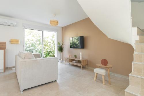 a living room with a couch and a table at Villa Mimosa in Marignane