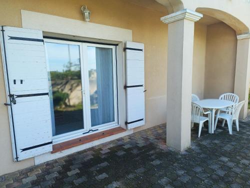 d'une terrasse avec une table et une grande fenêtre. dans l'établissement Bas de maison proche côte bleue, à Martigues