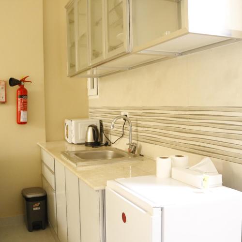 a kitchen with a sink and a microwave at Dar Al Noori Beach Apartment Managed by HPH in Salalah